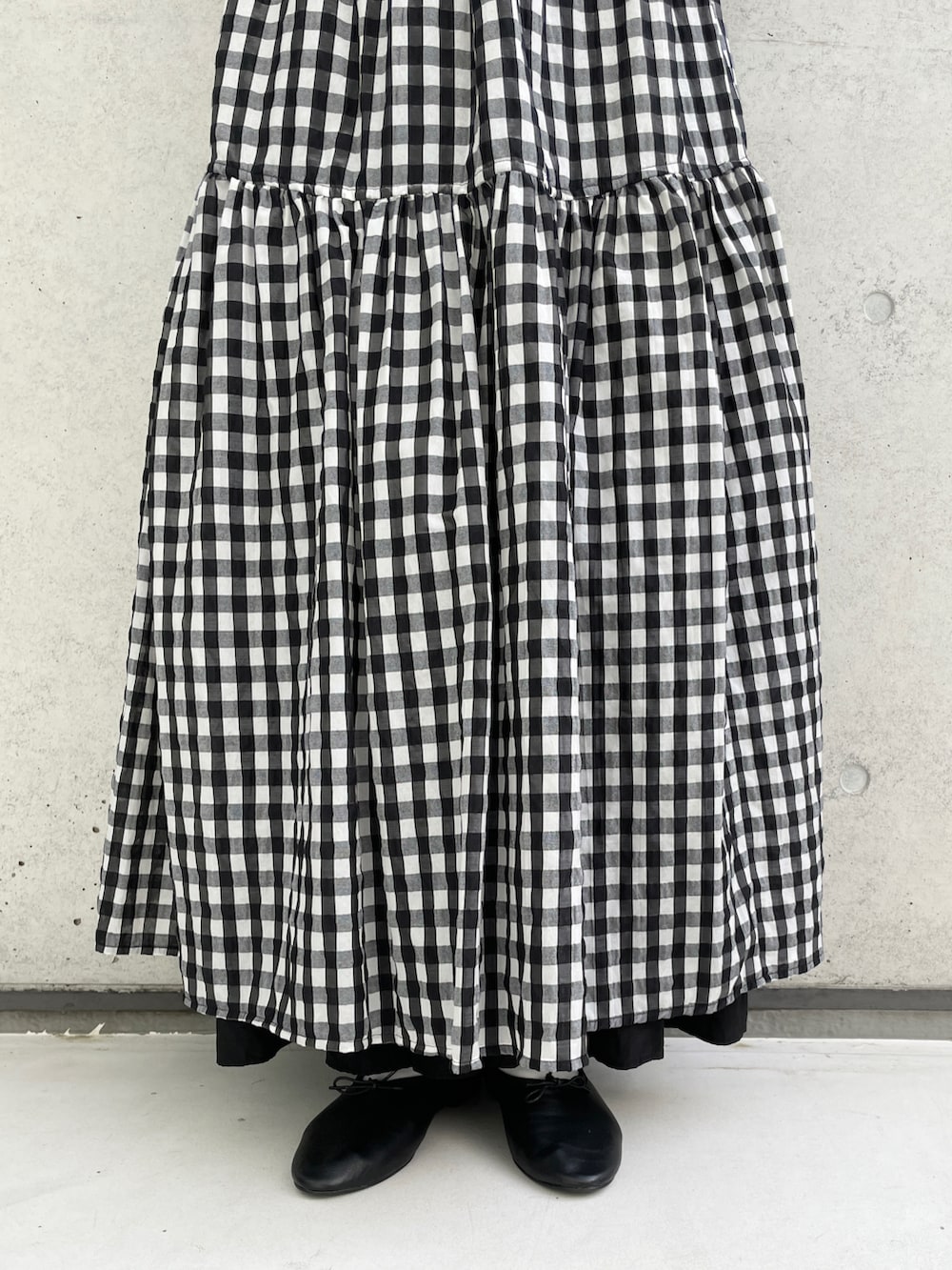 ブラック系のポロシャツ、ブラック系のワンピース/ドレス、ブラック系のバレエシューズを着用したレディースの春コーディネートの4枚目の写真