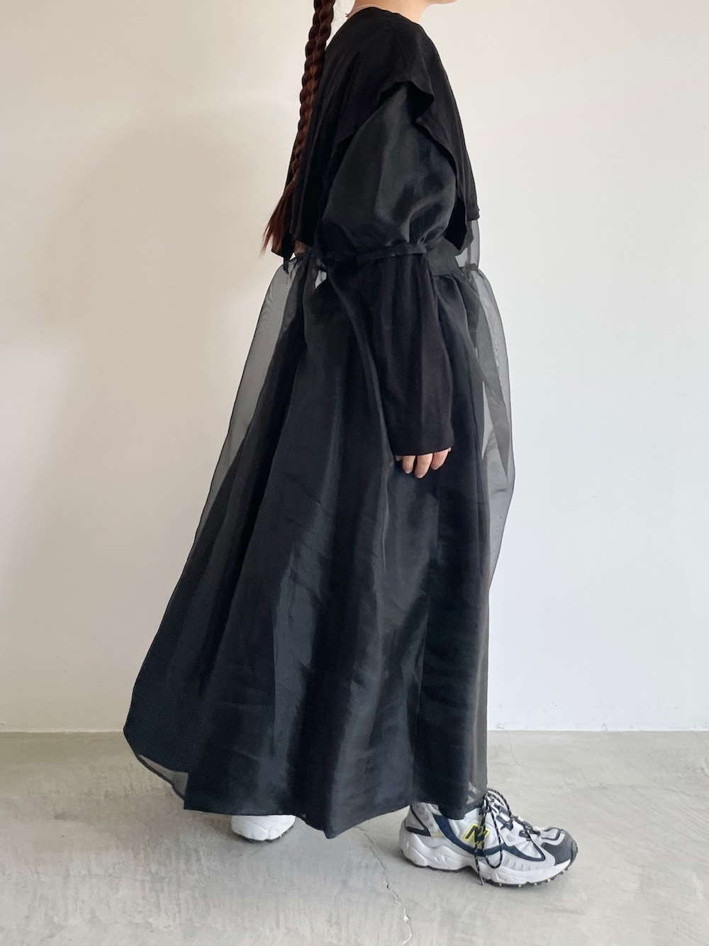 ブラック系のTシャツ/カットソー、ブラック系のワンピース、ベージュ系のキャップを着用したレディースの冬コーディネートの2枚目の写真