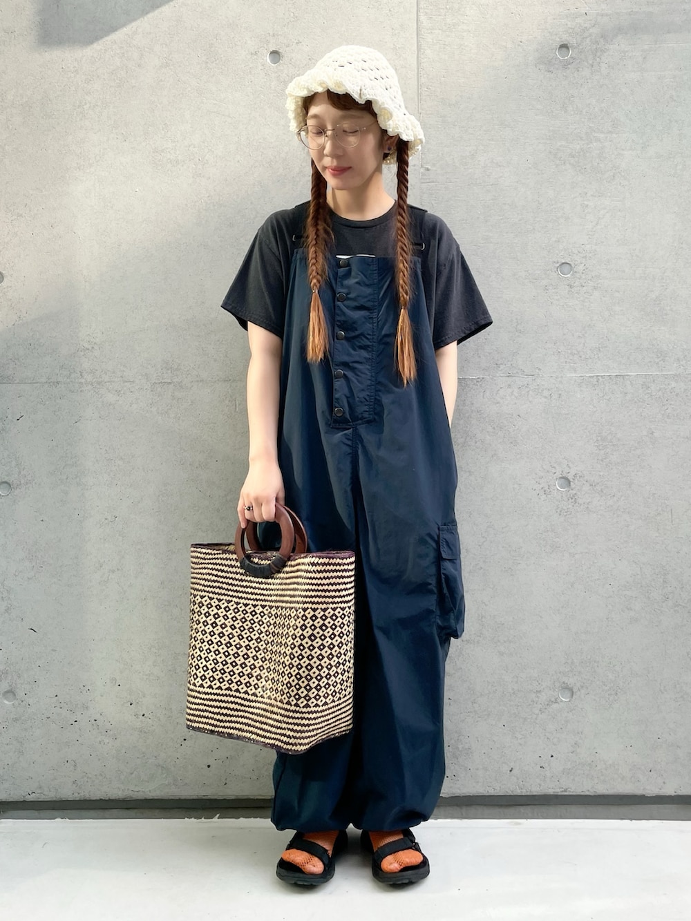 ブルー系のサロペット/オーバーオール、ブラック系のTシャツ/カットソー、ブラック系のサンダルを着用したレディースの夏コーディネートの2枚目の写真