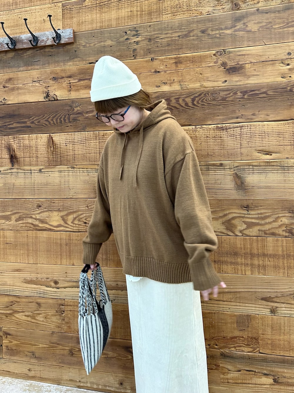 ベージュ系のニット/セーター、ホワイト系のスカート、その他のバッグを着用したレディースの冬コーディネートの3枚目の写真