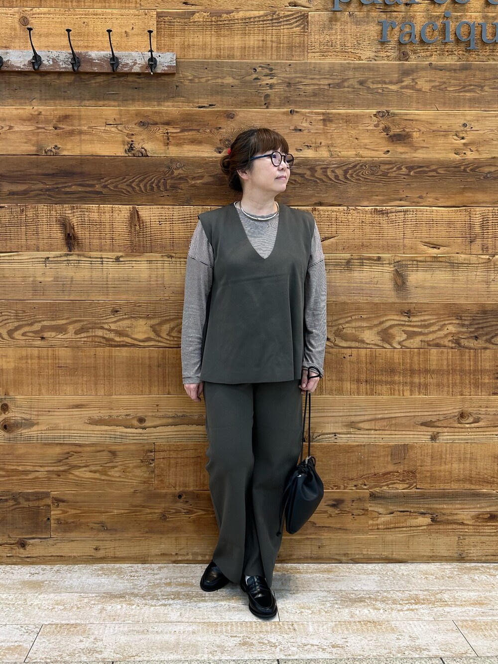 ブラウン系のTシャツ/カットソー、ブラウン系のベスト、ブラウン系のパンツを着用したレディースの秋コーディネートの2枚目の写真