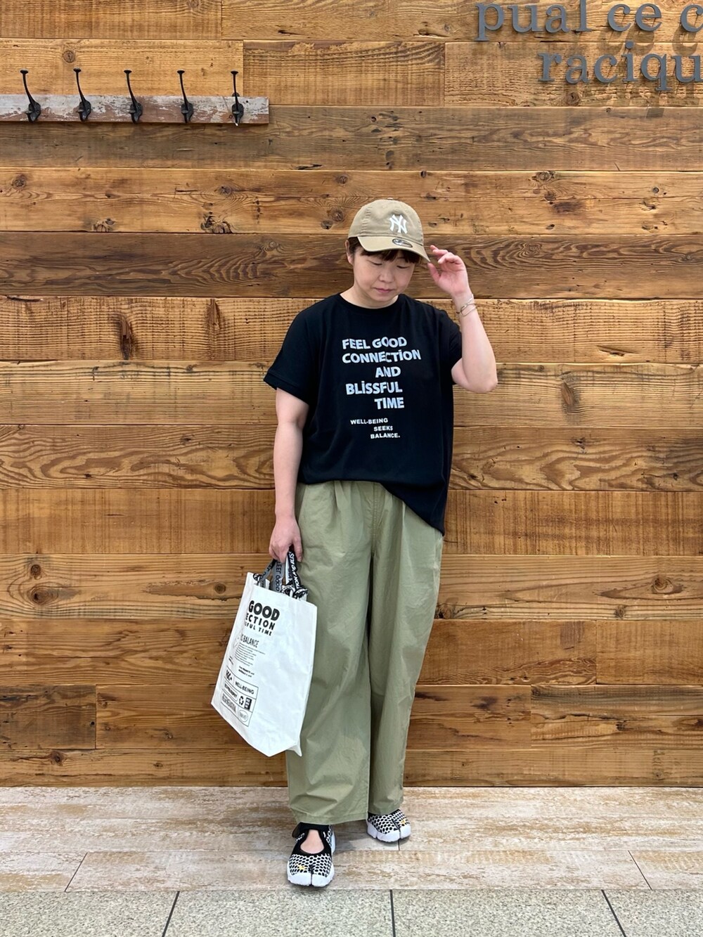 ブラック系のTシャツ/カットソー、グリーン系のパンツ、ホワイト系のショルダーバッグを着用したレディースの夏コーディネートの2枚目の写真