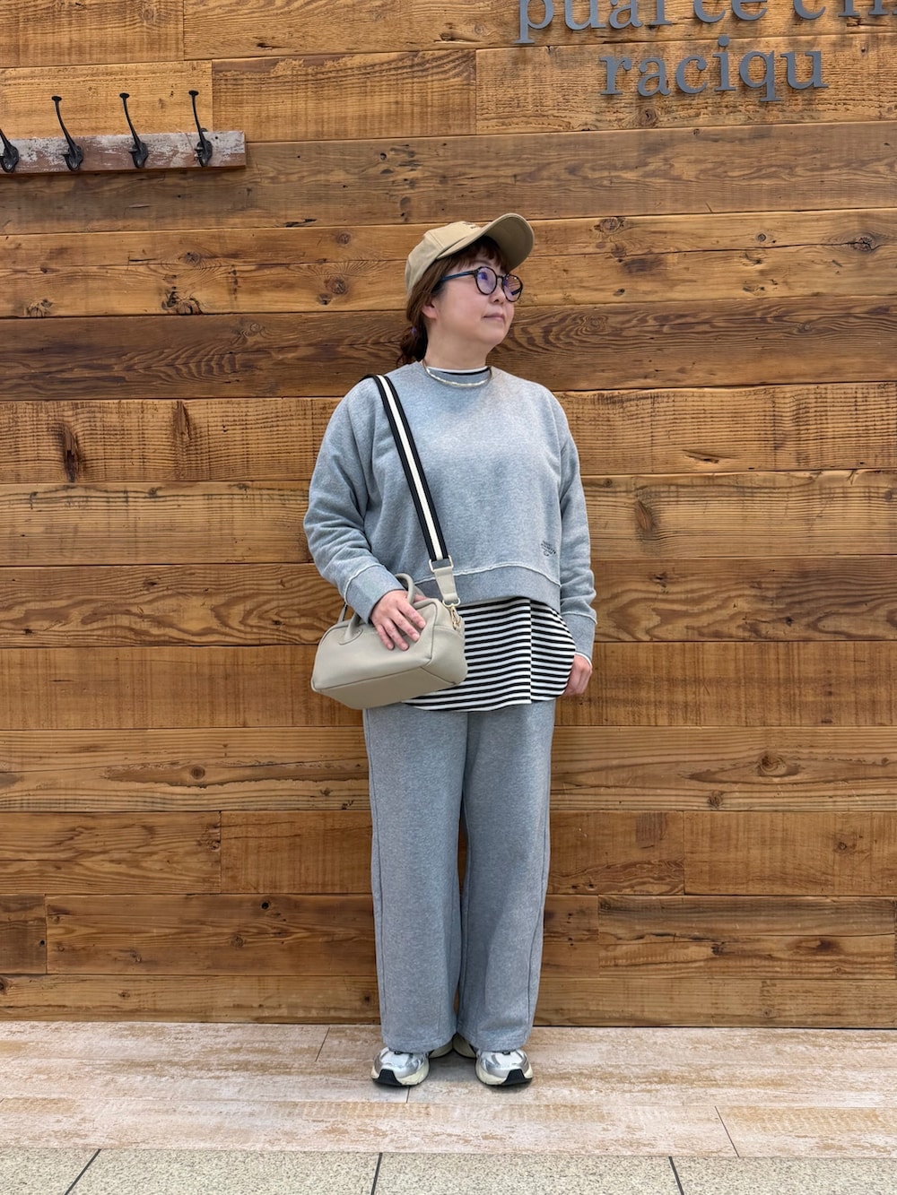 ベージュ系のショルダーバッグ、その他のTシャツ/カットソー、グレー系のパンツを着用したレディースの春コーディネートの2枚目の写真