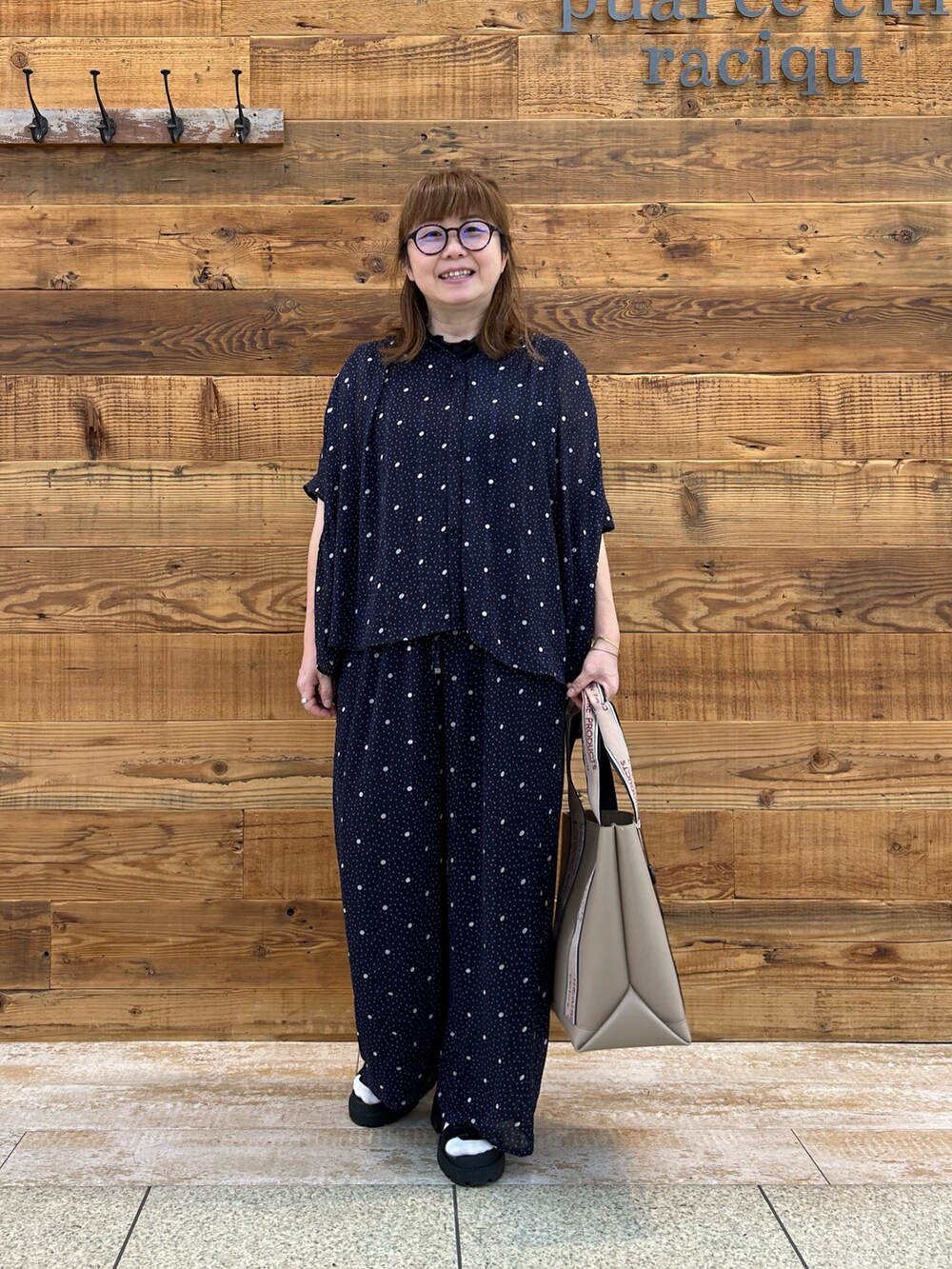 ブルー系のシャツ/ブラウス、ブルー系のパンツ、ベージュ系のバッグを着用したレディースの夏コーディネートの2枚目の写真