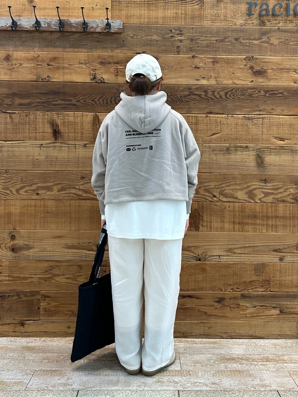 ベージュ系のトップス、ホワイト系のTシャツ/カットソー、ホワイト系のパンツを着用したレディースの春コーディネートの3枚目の写真