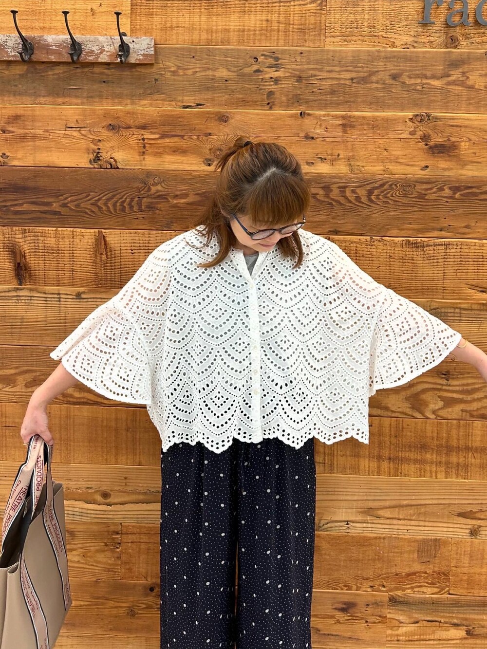 ホワイト系のシャツ/ブラウス、ブラック系のサンダル、ブルー系のパンツを着用したレディースの夏コーディネートの3枚目の写真