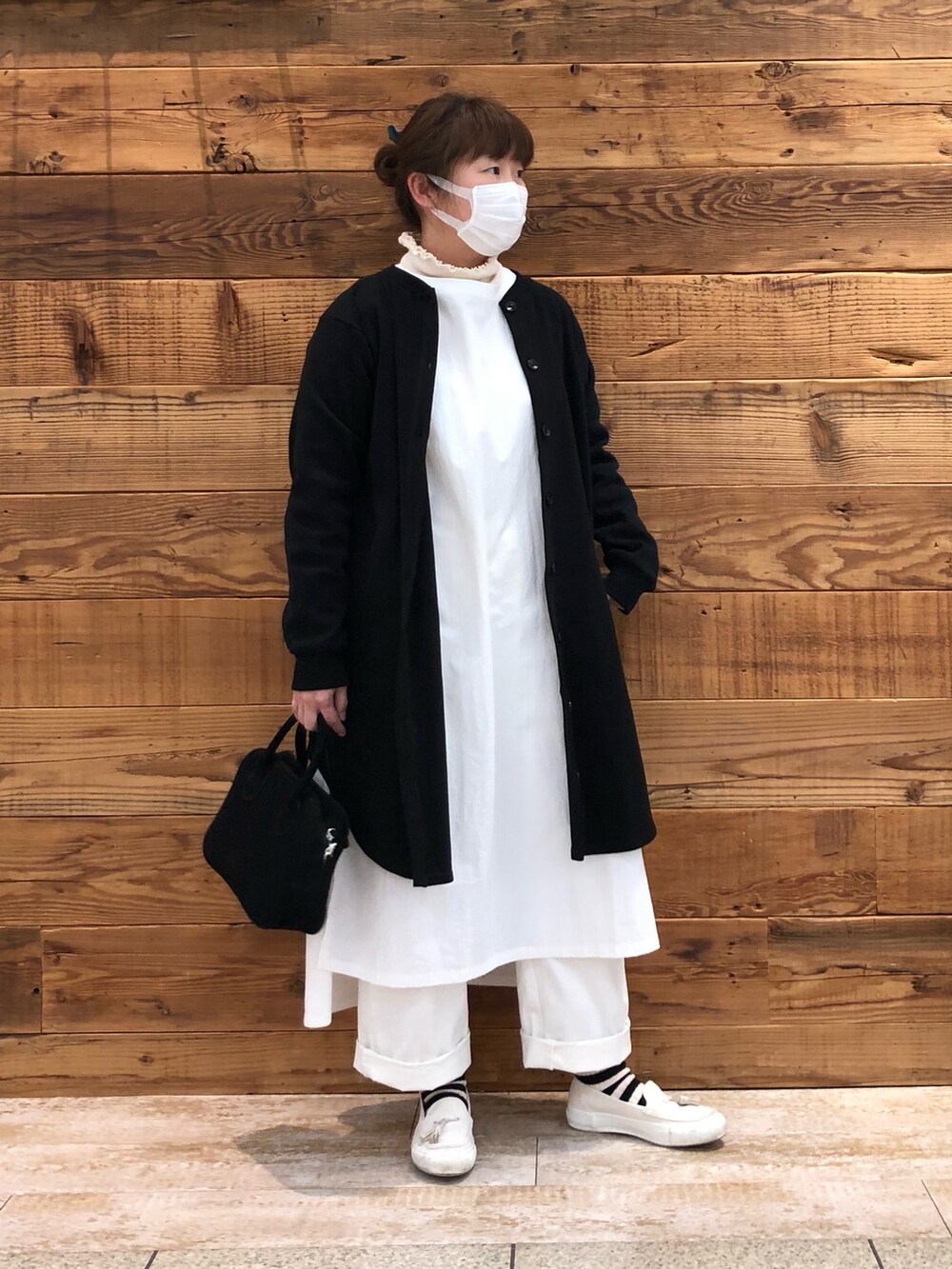 ホワイト系のワンピース、ブラック系のカーディガン/ボレロ、ホワイト系のその他パンツを着用したレディースの冬コーディネートの2枚目の写真