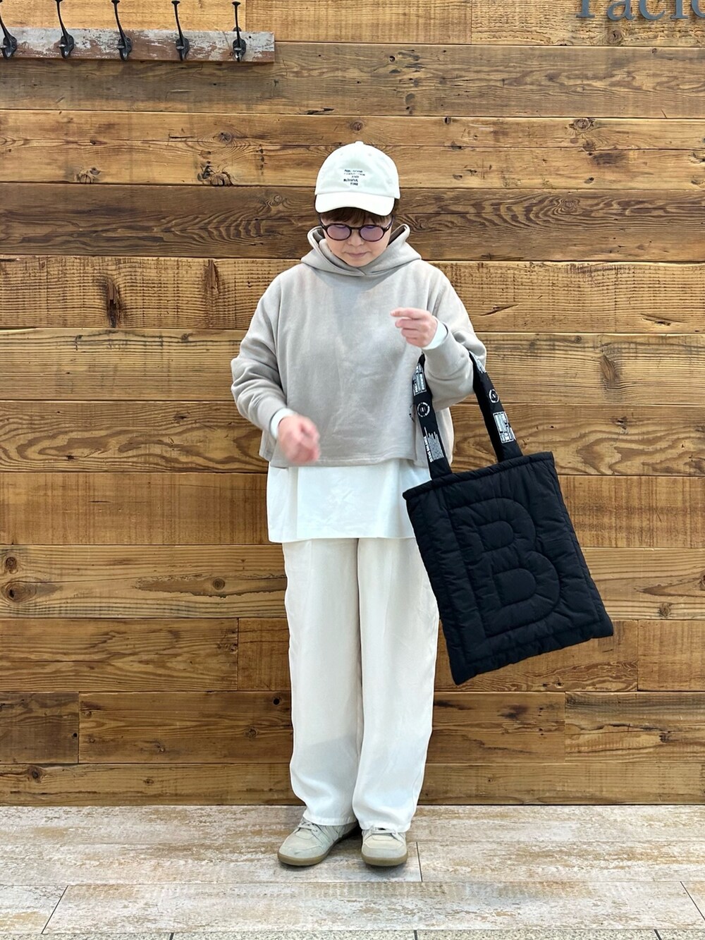 ベージュ系のトップス、ホワイト系のTシャツ/カットソー、ホワイト系のパンツを着用したレディースの春コーディネートの2枚目の写真