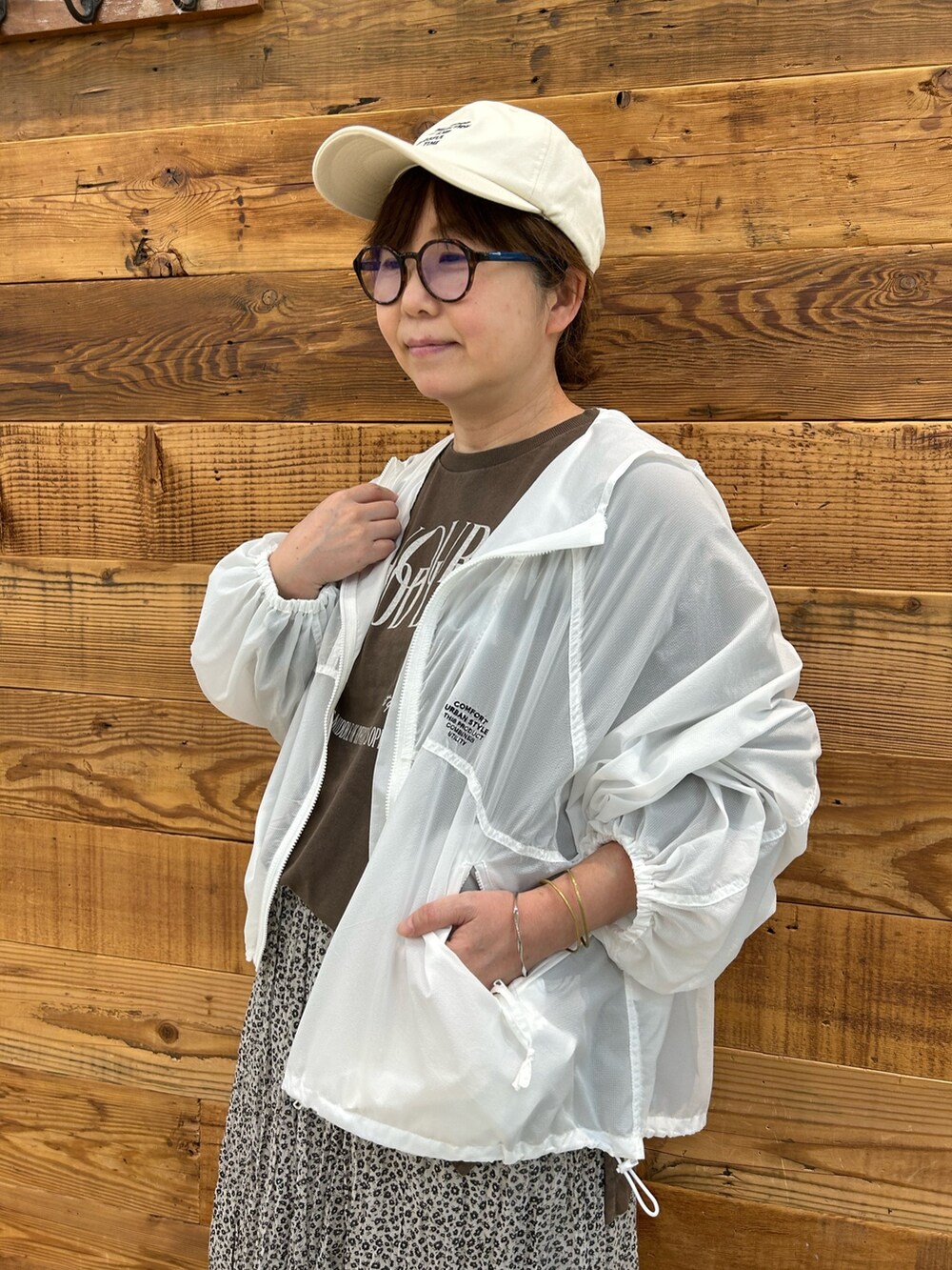ベージュ系のスカート、ホワイト系のジャケット/アウター、ブラウン系のTシャツ/カットソーを着用したレディースの夏コーディネートの3枚目の写真