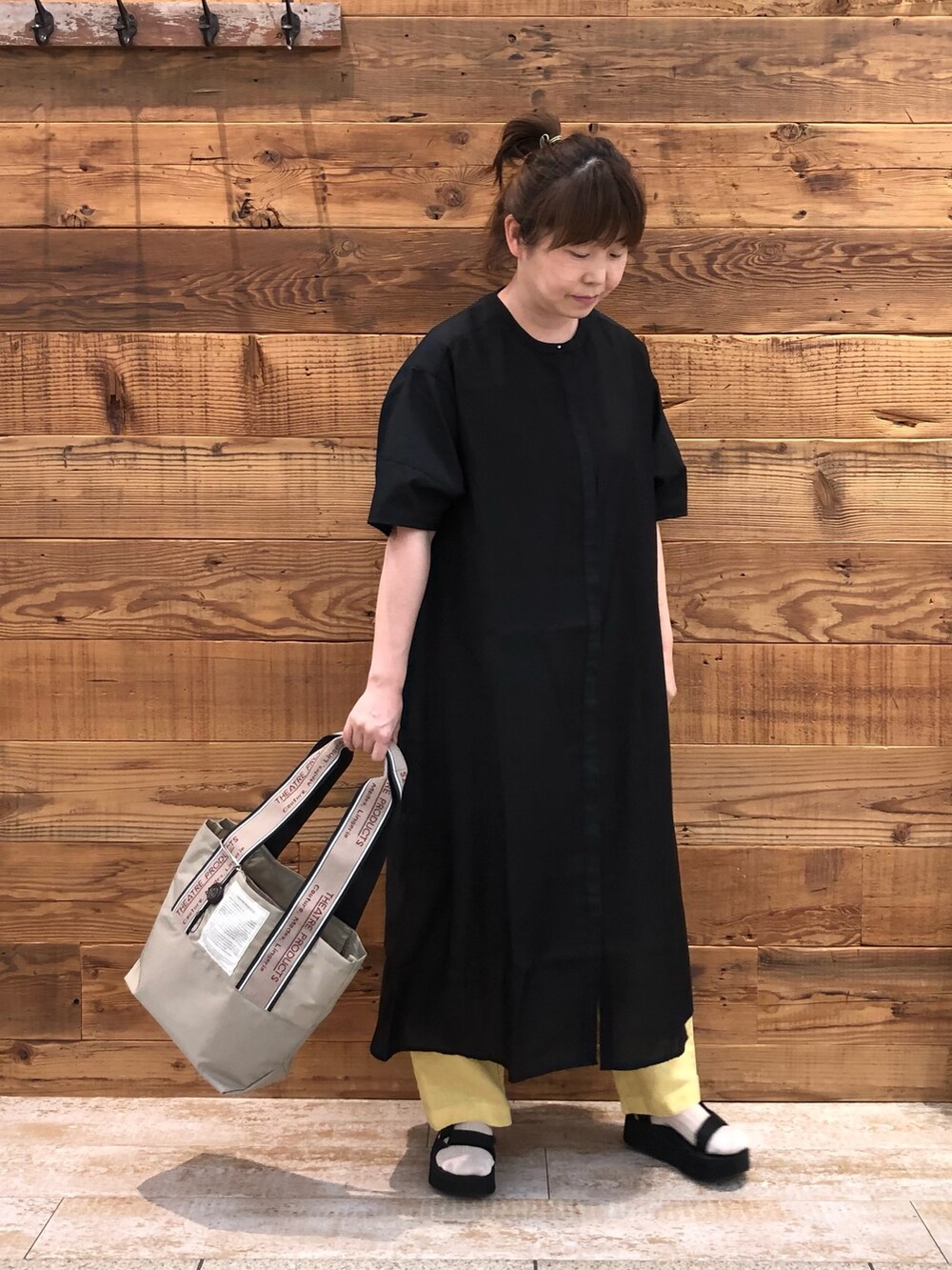 ブラック系のワンピース、イエロー系のその他パンツ、ベージュ系のトートバッグを着用したレディースの夏コーディネートの2枚目の写真