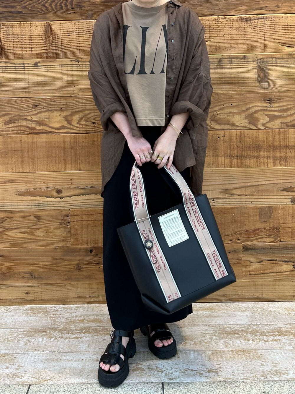 イエロー系のTシャツ/カットソー、ブラウン系のシャツ/ブラウス、ブラック系のサンダルを着用したレディースの夏コーディネートの3枚目の写真