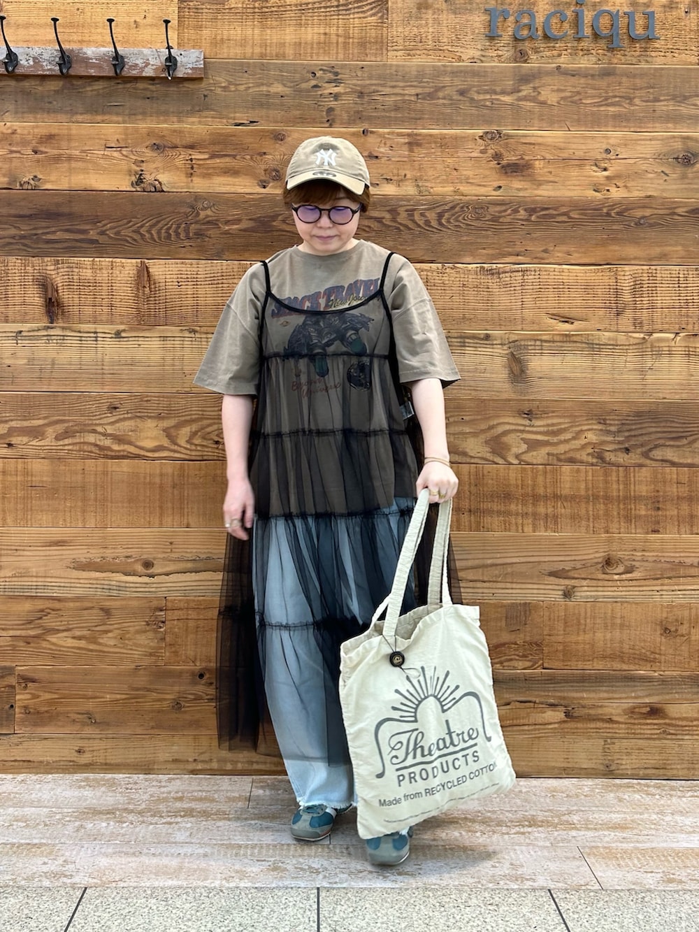 ベージュ系のTシャツ/カットソー、ブラック系のワンピース/ドレス、ベージュ系のバッグを着用したレディースの夏コーディネートの2枚目の写真