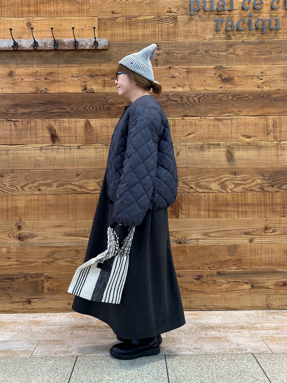 ブラック系のダウンジャケット/コート、グレー系のワンピース、その他のバッグを着用したレディースの冬コーディネートの2枚目の写真