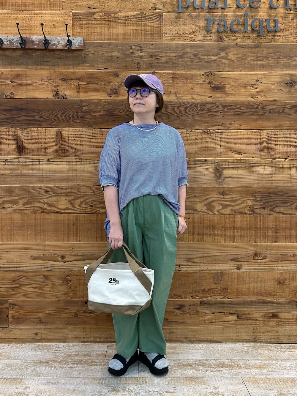 ブルー系のTシャツ/カットソー、ベージュ系のバッグ、グリーン系のその他パンツを着用したレディースの夏コーディネートの2枚目の写真