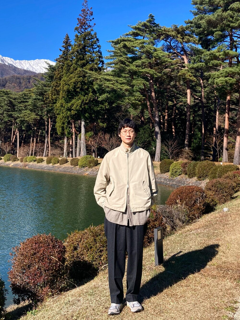 グリーン系のカーゴパンツ、シルバー系のスニーカー、シルバー系のMA-1を着用したメンズの秋コーディネートの2枚目の写真