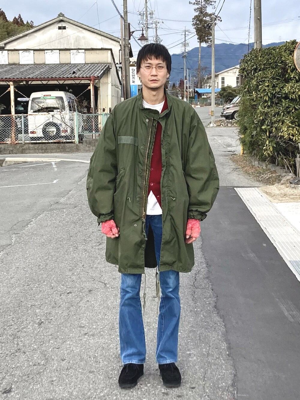 ブラック系のローファー、ブラック系のデニムパンツ、ブルー系のベストを着用したメンズの冬コーディネートの2枚目の写真