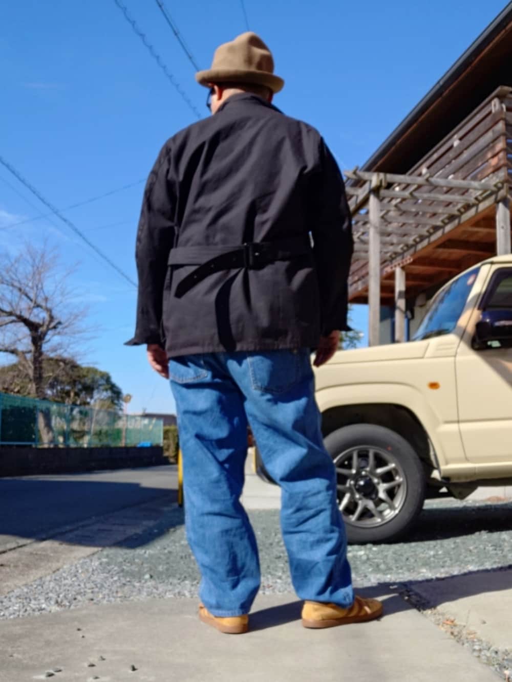 グレー系のニット/セーター、ブラック系のライダースジャケット、ブルー系のデニムパンツを着用したメンズの冬コーディネートの2枚目の写真