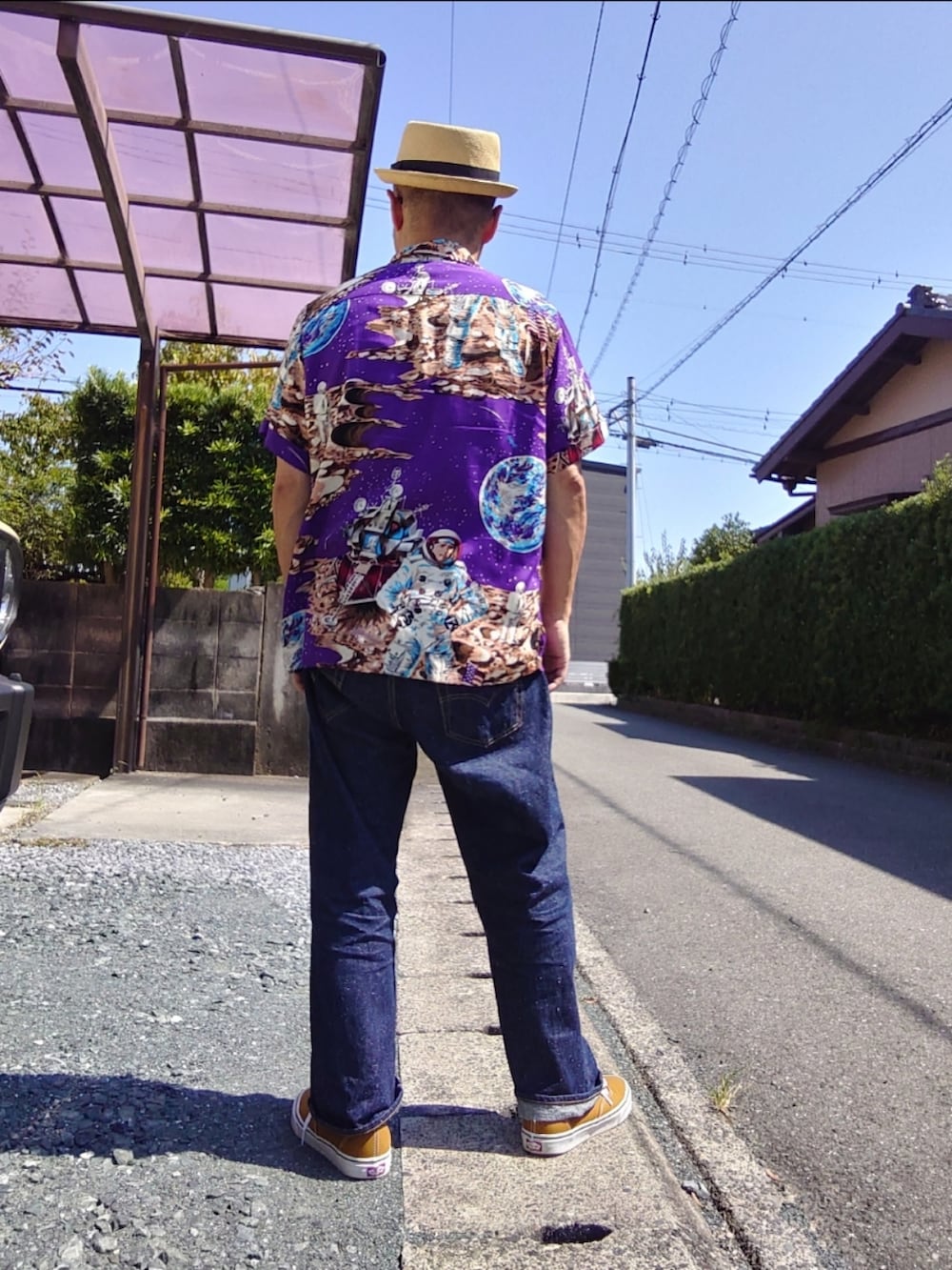 パープル系のシャツ/ブラウス、ブルー系のデニムパンツ、ブラウン系のスニーカーを着用したメンズの秋コーディネートの2枚目の写真