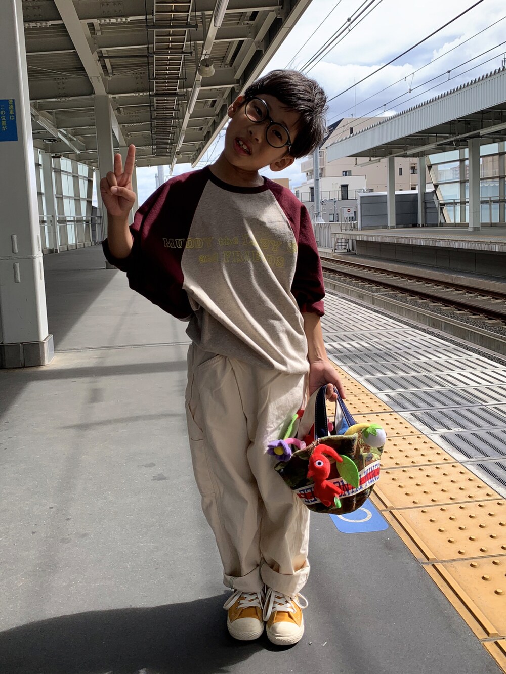 グレー系のTシャツ/カットソー、ホワイト系のパンツ、イエロー系のスニーカーを着用したキッズの秋コーディネートの2枚目の写真