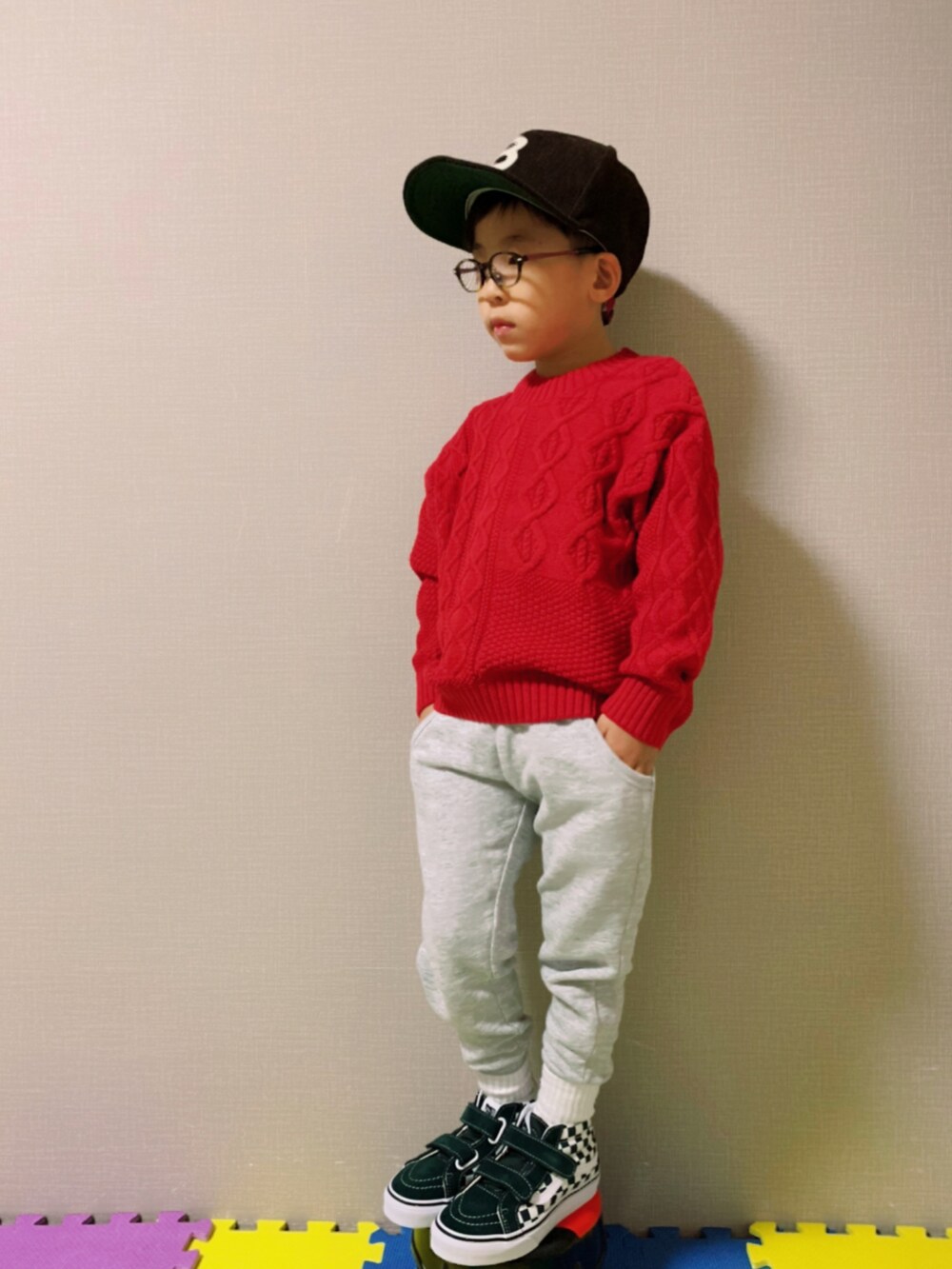 レッド系のニット/セーター、グレー系のその他パンツ、グリーン系のスニーカーを着用したキッズの秋コーディネートの2枚目の写真
