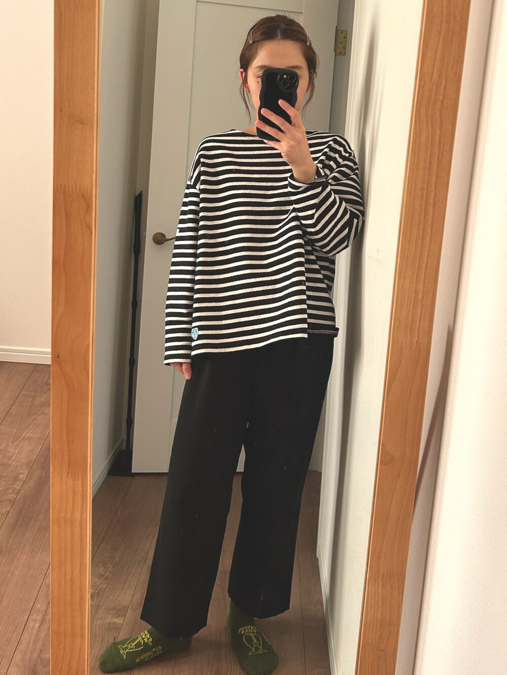 ブラック系のTシャツ/カットソー、ブラック系のスラックス、グリーン系のソックス/靴下を着用したレディースの秋コーディネートの2枚目の写真