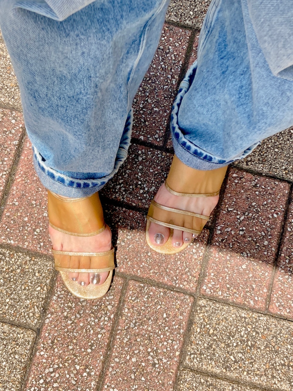 ブラウン系のタンクトップ、ホワイト系のシャツ/ブラウス、ブルー系のデニムパンツを着用したレディースの春コーディネートの2枚目の写真
