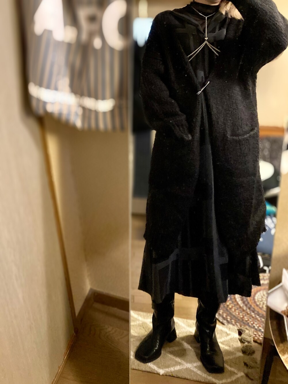 ブラック系のTシャツ/カットソー、ブラック系のドレス、ブラック系のブーツを着用したレディースの冬コーディネートの2枚目の写真