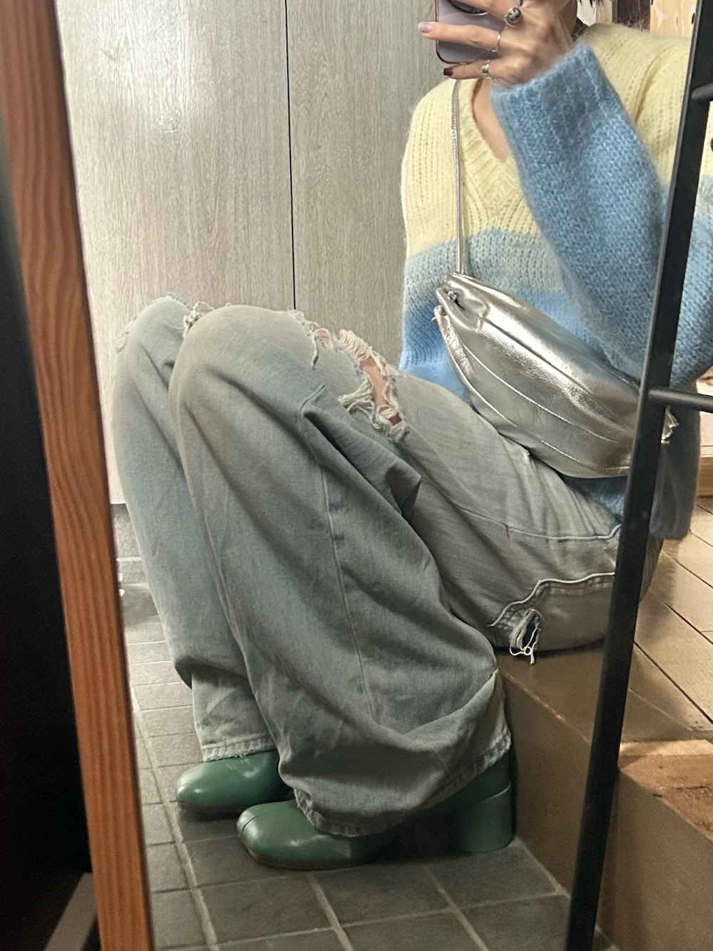イエロー系のニット/セーター、ブルー系のデニムパンツ、シルバー系のショルダーバッグを着用したレディースの秋コーディネートの2枚目の写真
