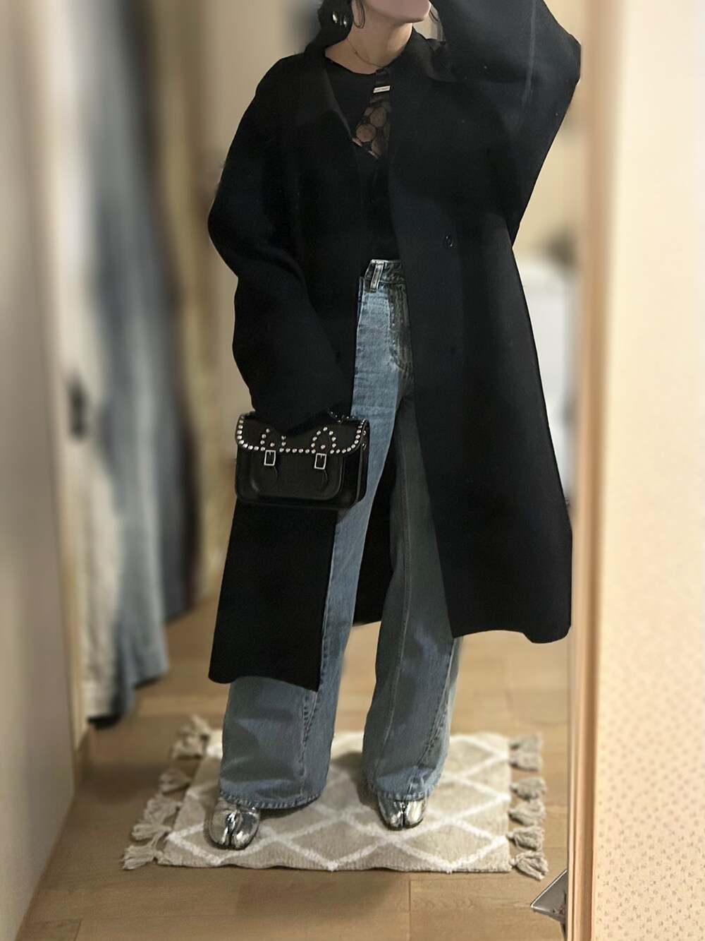 ブラック系のTシャツ/カットソー、ブラック系のカーディガン/ボレロ、ブルー系のデニムパンツを着用したレディースの冬コーディネートの2枚目の写真