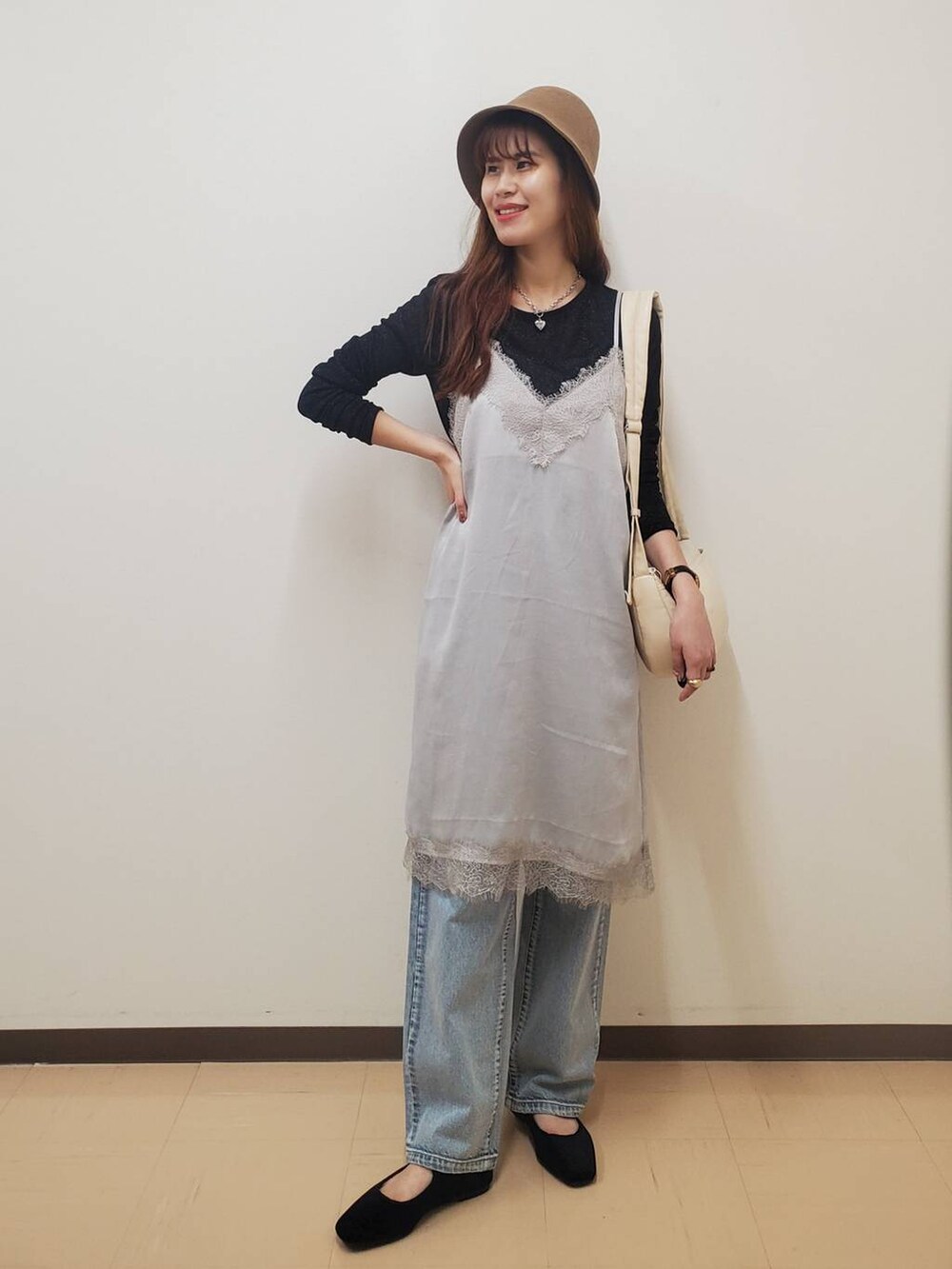 ホワイト系のショルダーバッグ、ブルー系のデニムパンツ、その他のパンプスを着用したレディースの秋コーディネートの2枚目の写真