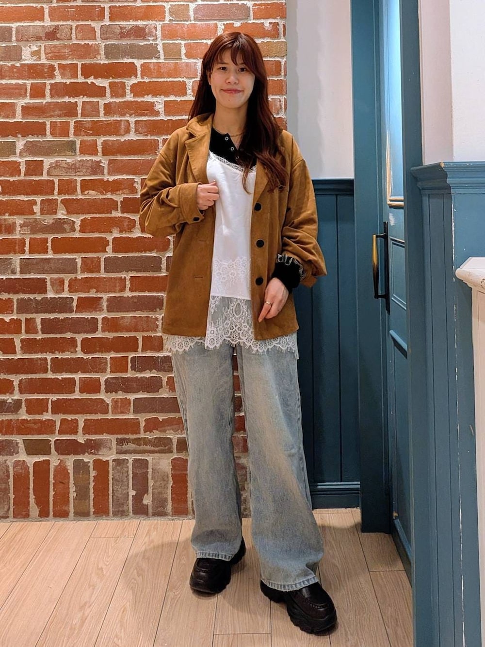 ブラック系のニット/セーター、ブルー系のデニムパンツ、ブラック系のローファーを着用したレディースの春コーディネートの2枚目の写真