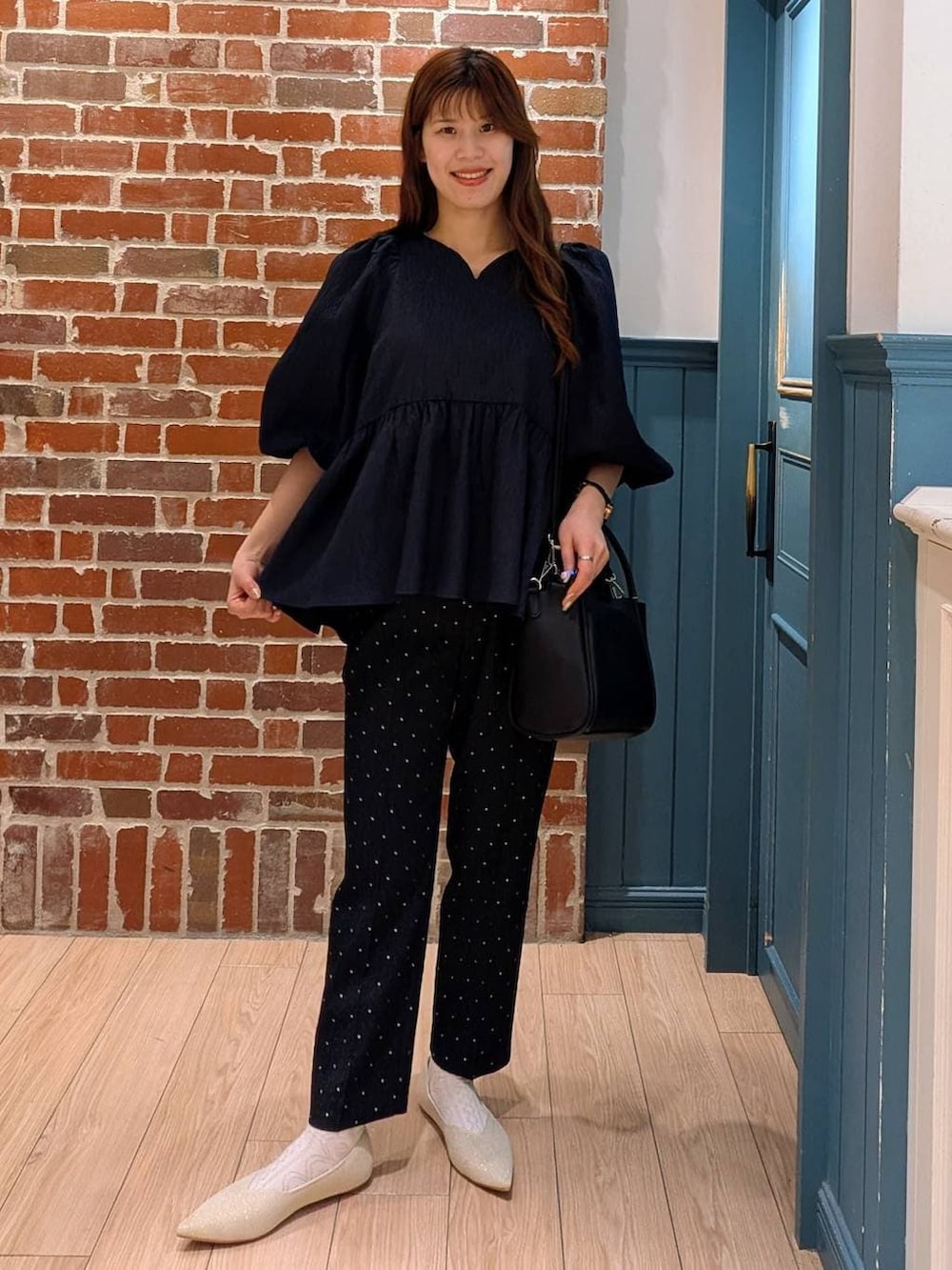 ブラック系のショルダーバッグ、ブルー系のシャツ/ブラウス、ブラック系のその他パンツを着用したレディースの冬コーディネートの2枚目の写真