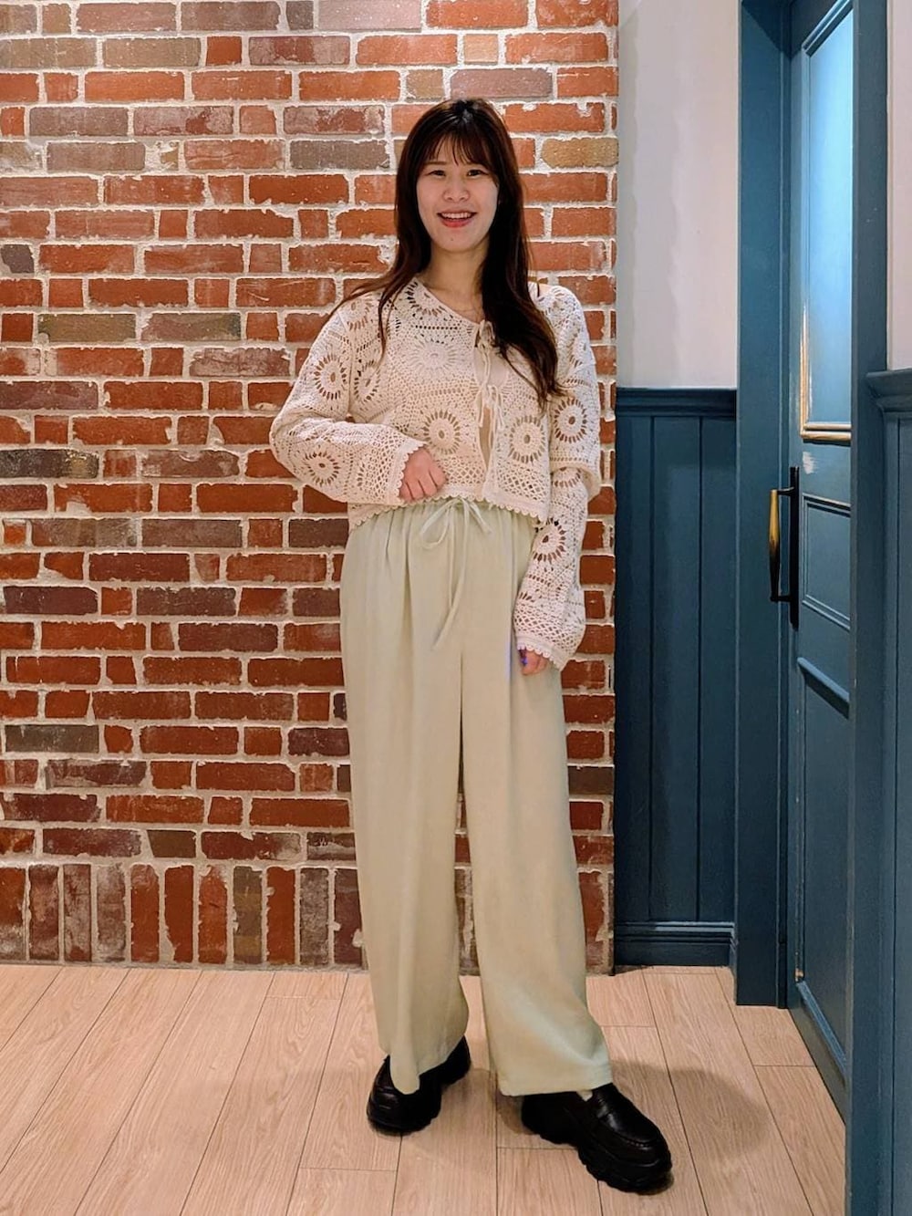 ブラック系のローファー、ホワイト系のタンクトップ、グリーン系のその他パンツを着用したレディースの春コーディネートの2枚目の写真