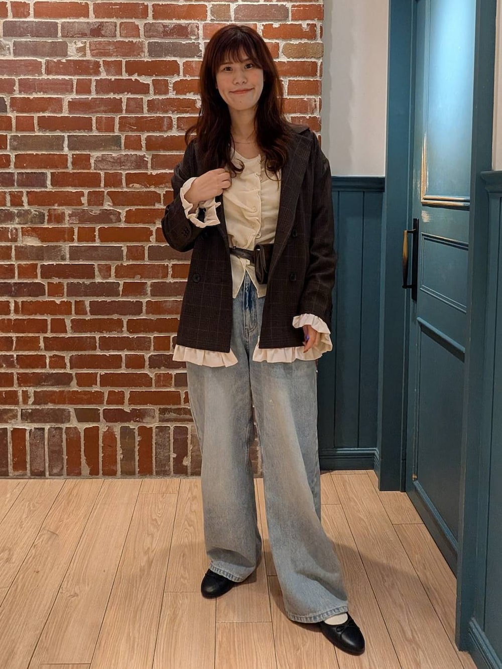 ブラック系のバレエシューズ、ホワイト系のTシャツ/カットソー、ブルー系のデニムパンツを着用したレディースの秋コーディネートの2枚目の写真