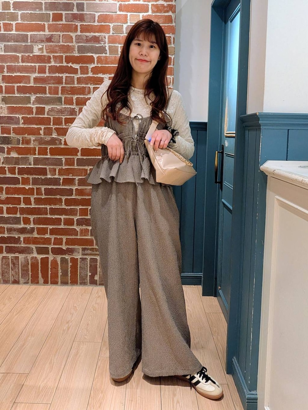 ベージュ系のショルダーバッグ、ホワイト系のTシャツ/カットソー、ブラウン系のサロペット/オーバーオールを着用したレディースの春コーディネートの2枚目の写真