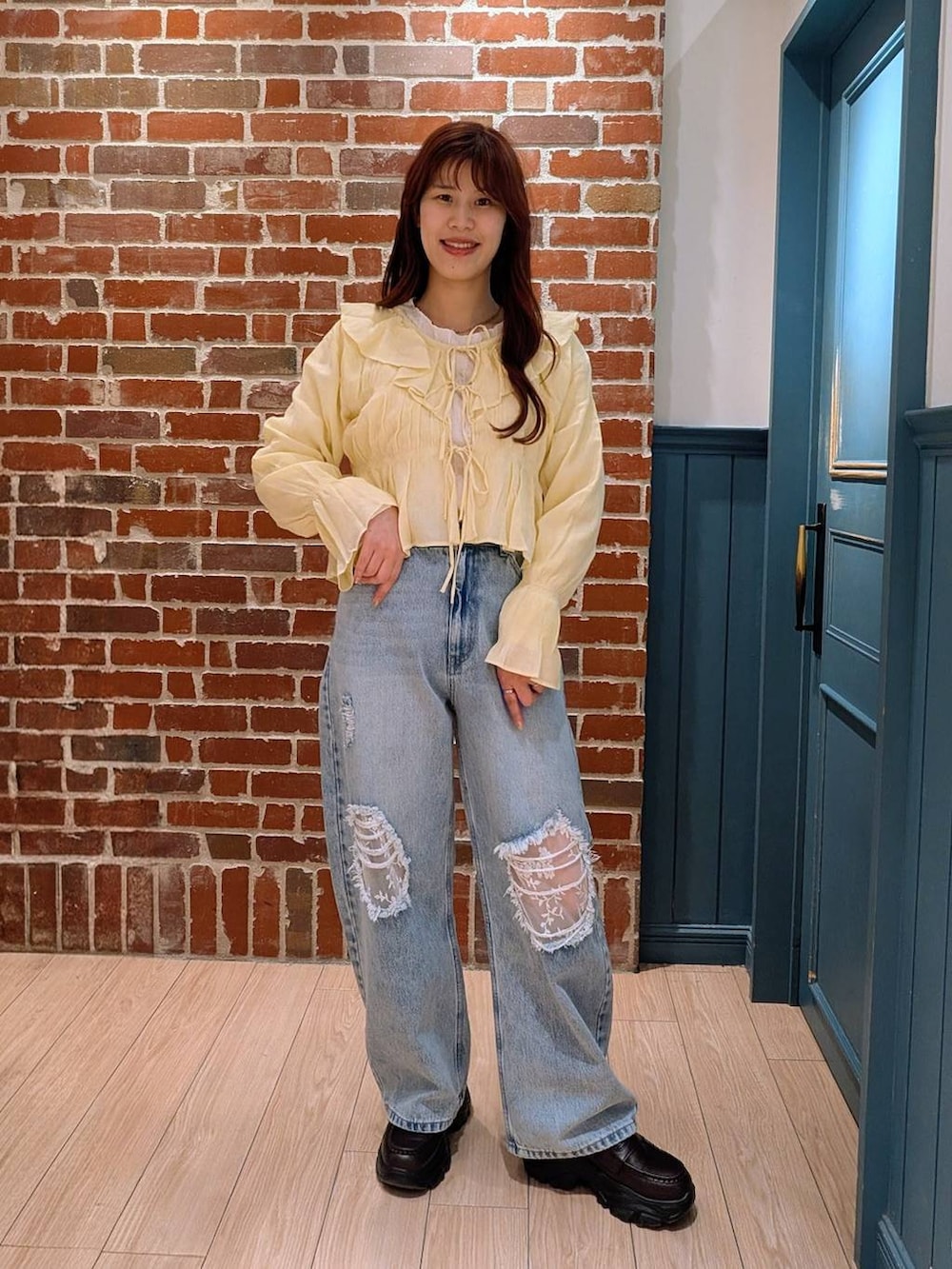 ブルー系のデニムパンツ、ブラック系のローファー、イエロー系のシャツ/ブラウスを着用したレディースの春コーディネートの2枚目の写真