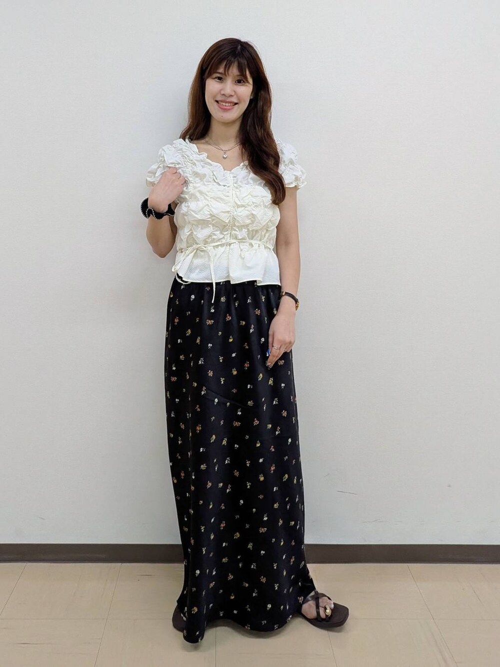 ホワイト系のシャツ/ブラウス、ブラック系のスカート、ブラウン系のサンダルを着用したレディースの夏コーディネートの2枚目の写真