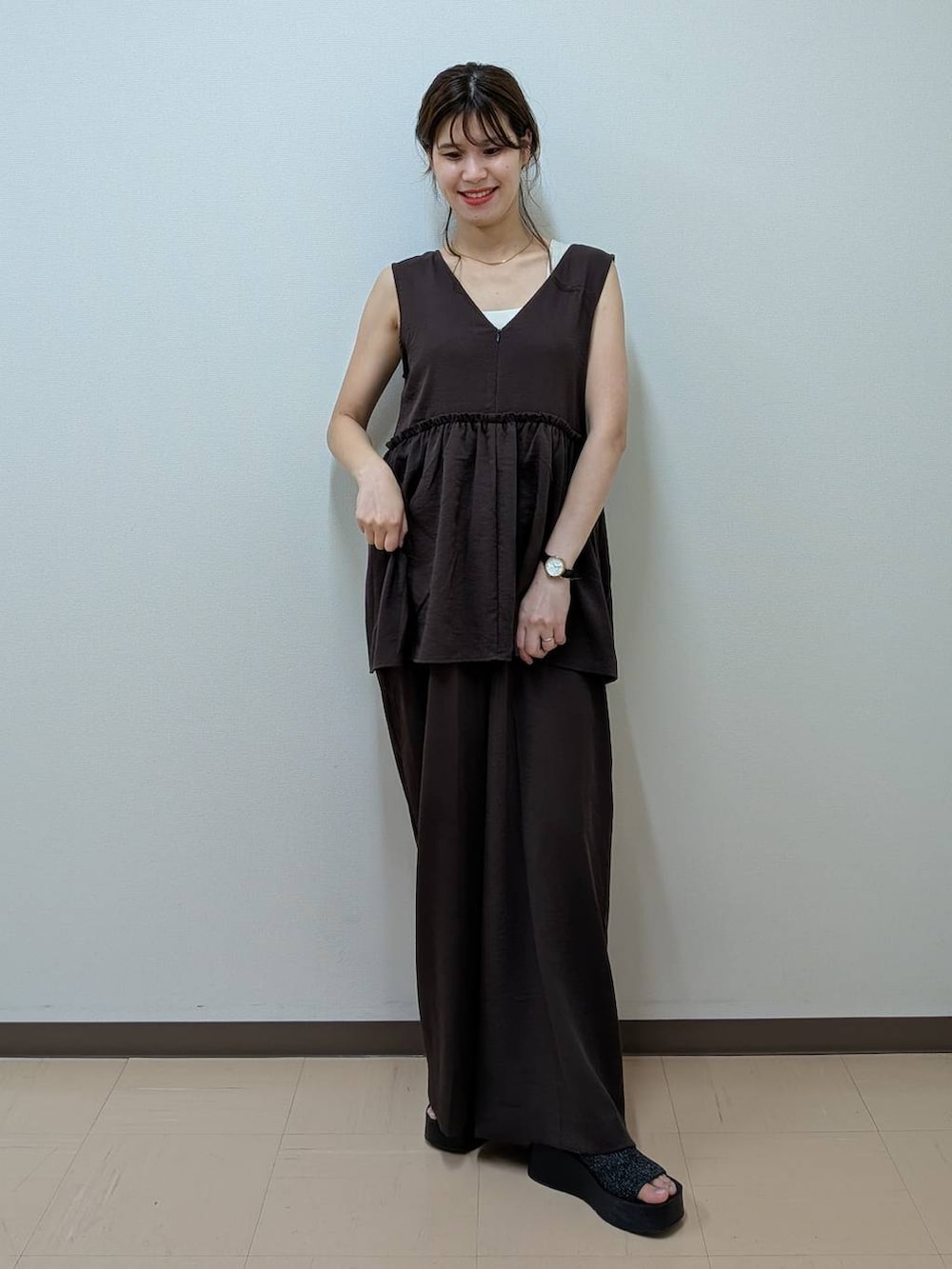 ブラック系のサンダル、ゴールド系のタンクトップ、ブラウン系のサロペット/オーバーオールを着用したレディースの夏コーディネートの2枚目の写真