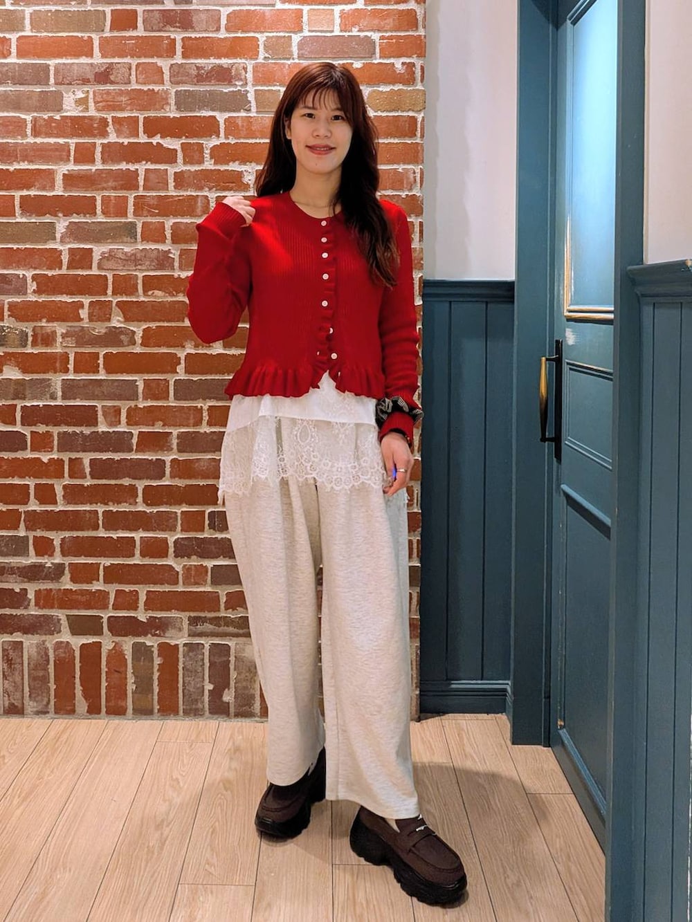 グレー系のスウェットパンツ、ブラウン系のローファー、レッド系のTシャツ/カットソーを着用したレディースの春コーディネートの2枚目の写真