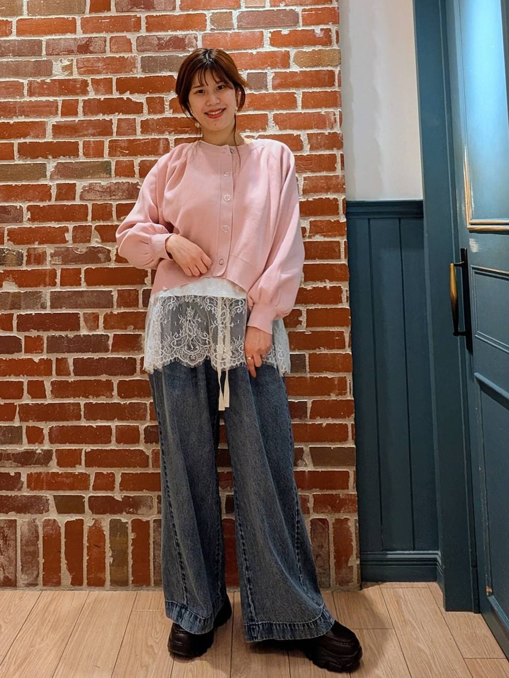 ブルー系のデニムパンツ、ブラック系のローファー、ピンク系のカーディガン/ボレロを着用したレディースの春コーディネートの2枚目の写真