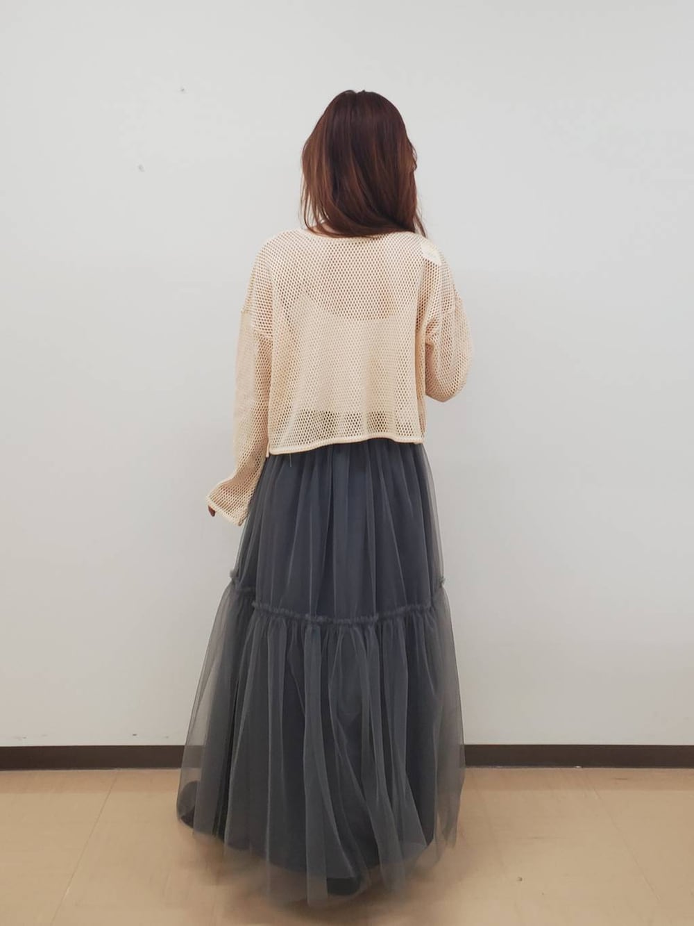 ホワイト系のキャミソール、ホワイト系のカーディガン/ボレロ、ブラック系のブーツを着用したレディースの秋コーディネートの3枚目の写真