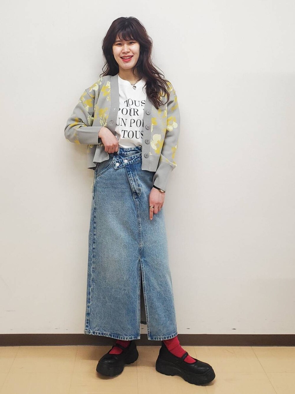 ブラック系のスニーカー、ホワイト系のTシャツ/カットソー、ブルー系のスカートを着用したレディースの冬コーディネートの2枚目の写真