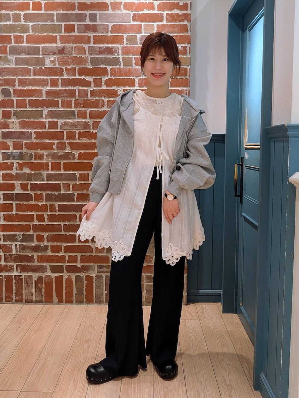 グレー系のパーカー、ブラック系のサンダル、ブラック系のその他パンツを着用したレディースの春コーディネートの2枚目の写真