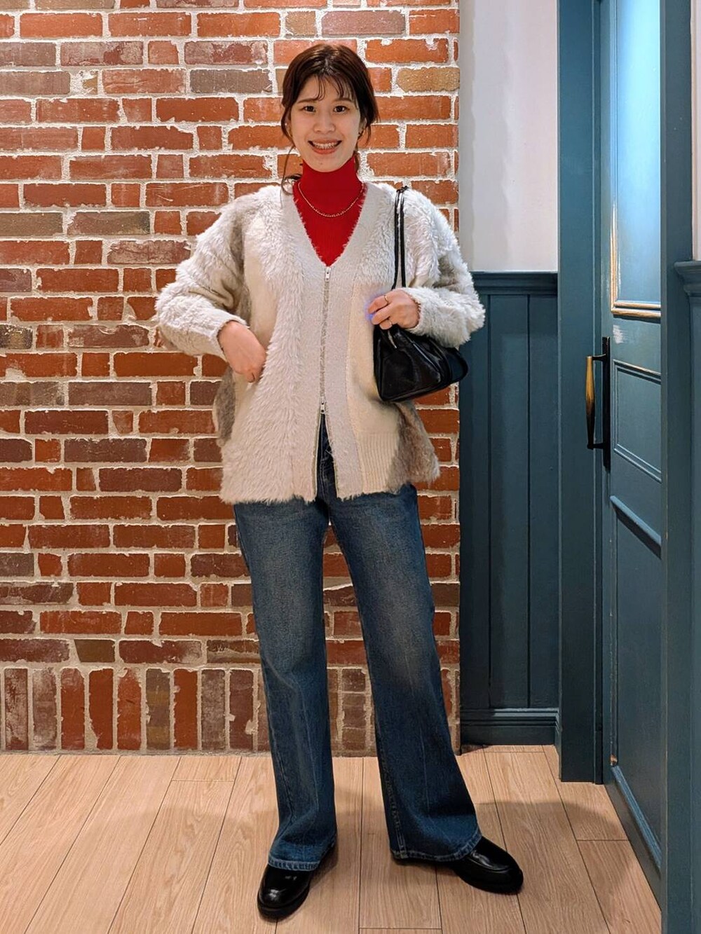 ホワイト系のカーディガン/ボレロ、レッド系のニット/セーター、ブラック系のローファーを着用したレディースの秋コーディネートの2枚目の写真