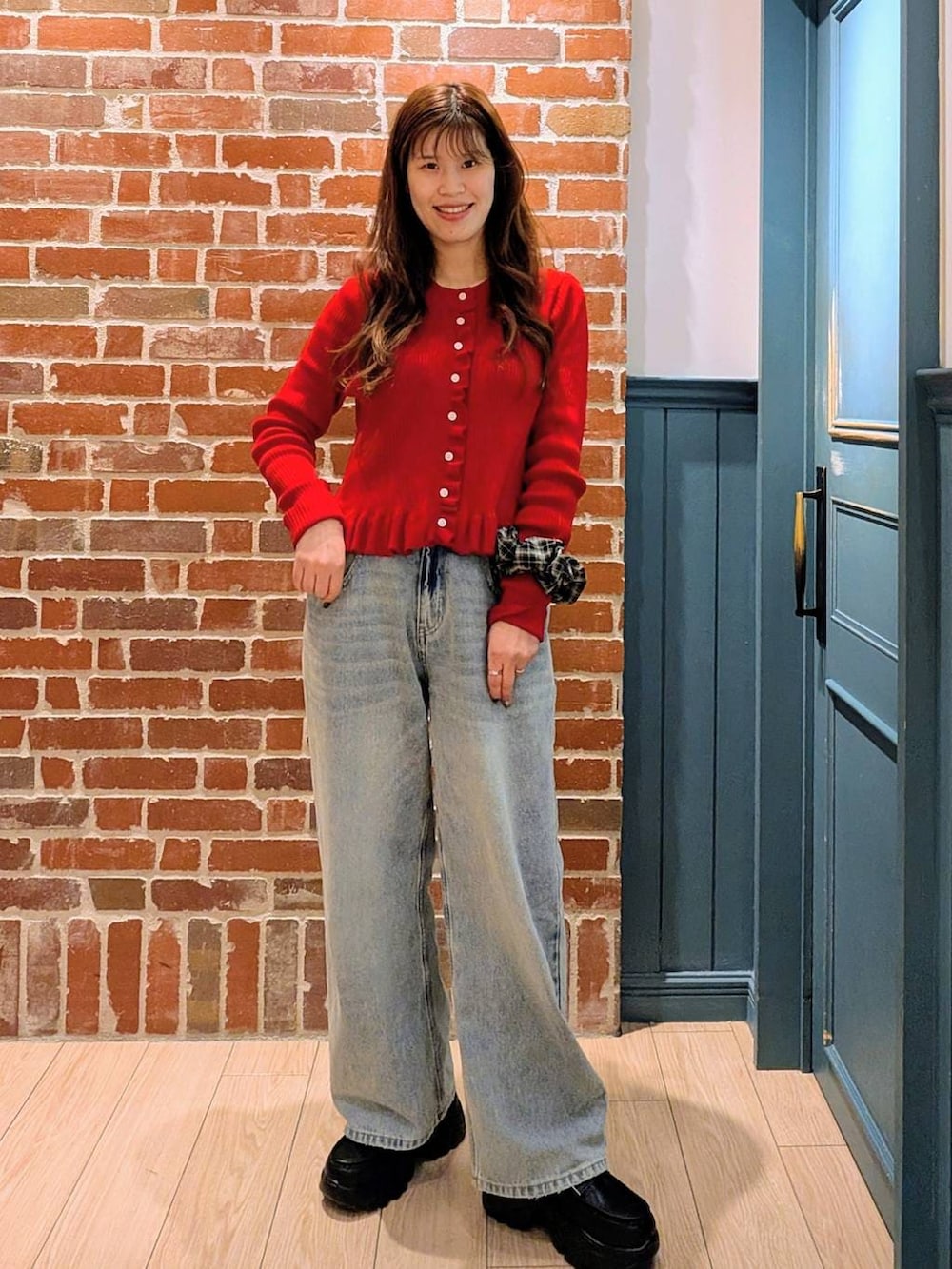 ブルー系のデニムパンツ、ブラック系のローファー、レッド系のTシャツ/カットソーを着用したレディースの冬コーディネートの2枚目の写真