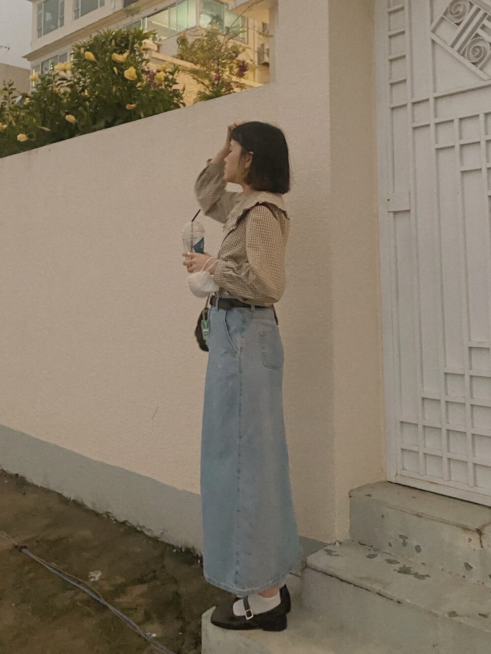 ブルー系のデニムスカート、ブラウン系のシャツ/ブラウス、ブラウン系のショルダーバッグを着用したレディースの春コーディネートの3枚目の写真