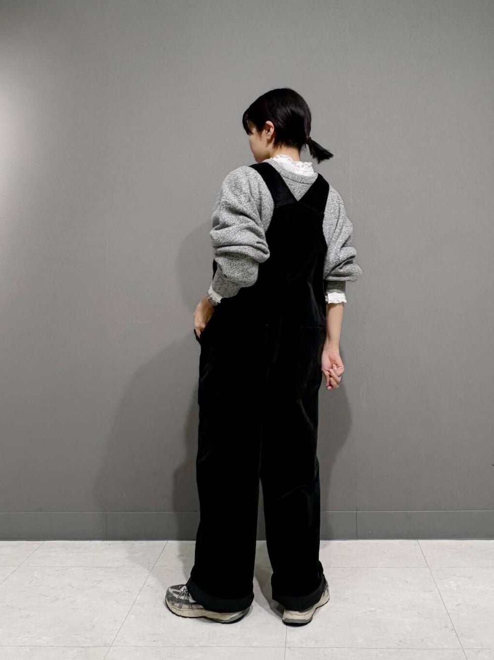 グレー系のニット/セーター、ホワイト系のシャツ/ブラウス、ブラック系のサロペット/オーバーオールを着用したレディースの冬コーディネートの4枚目の写真