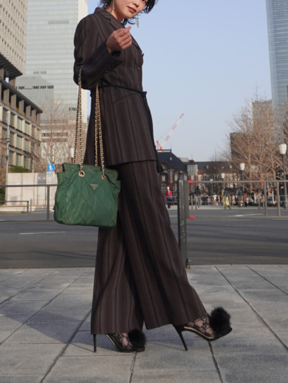 パープル系のスーツジャケット、パープル系のスーツパンツ、ブラック系のシューズを着用したレディースの春コーディネートの2枚目の写真