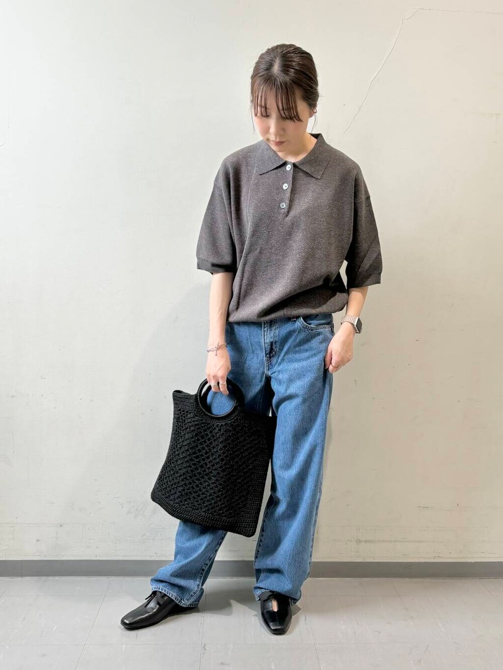 ブルー系のデニムパンツ、ブラック系のトートバッグ、グレー系のニット/セーターを着用したレディースの夏コーディネートの4枚目の写真