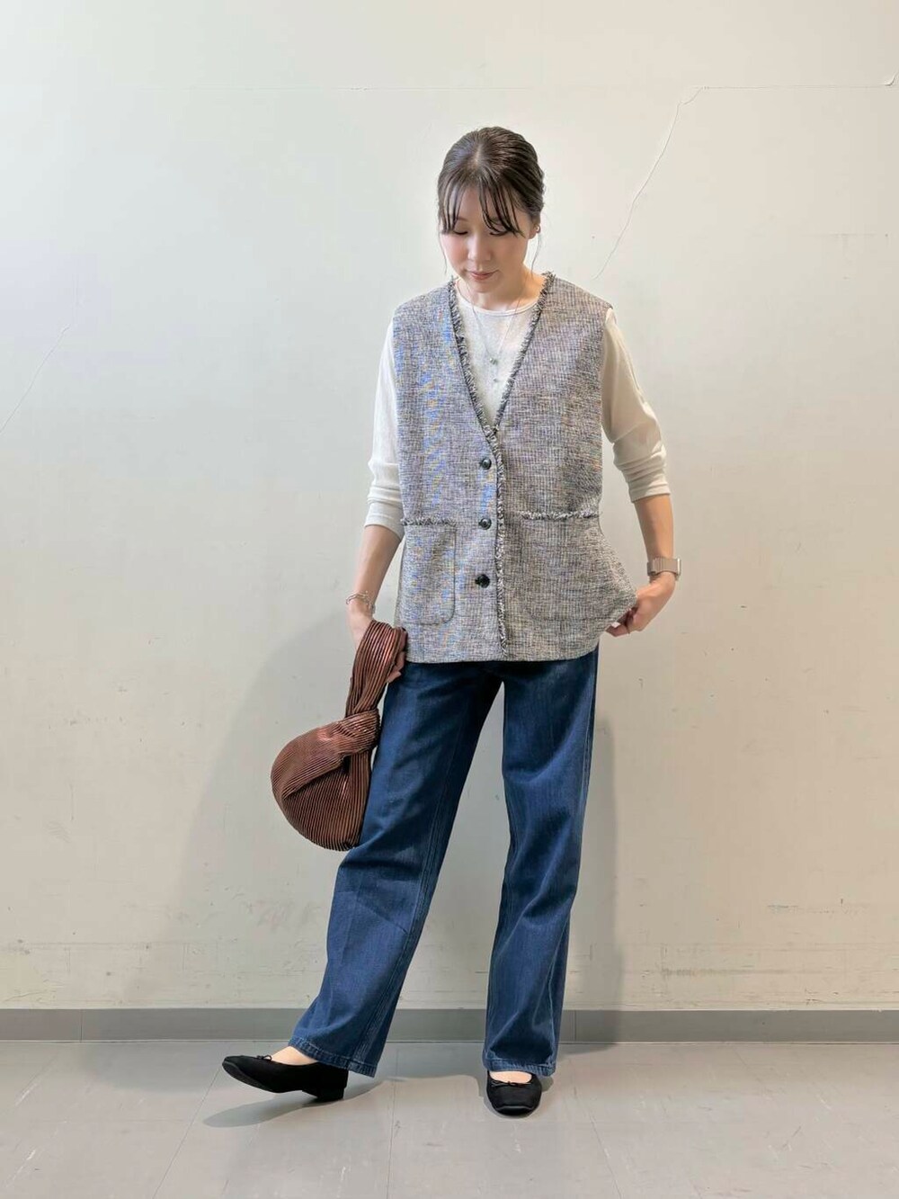 ブラウン系のハンドバッグ、ブラック系のバレエシューズ、ホワイト系のTシャツ/カットソーを着用したレディースの秋コーディネートの4枚目の写真